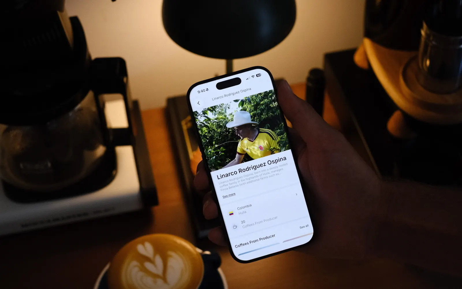 The Siip app showing a coffee farmer's page, held over a cup of coffee